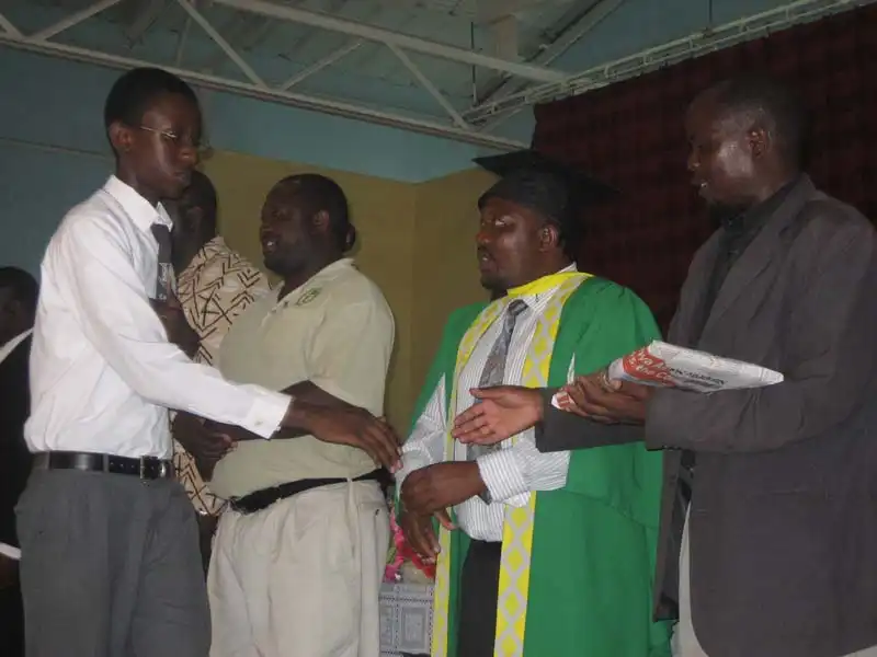 Receiving an award from the Headmaster (robed in University of Zambia dress) and a present (notice the newspaper wrapping) from the District Head.